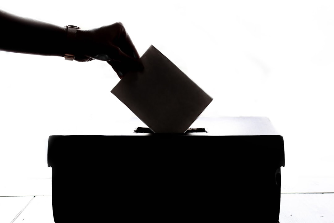 A voter placing a ballot paper into a ballot box, illustrating Kenya’s election-date court ruling